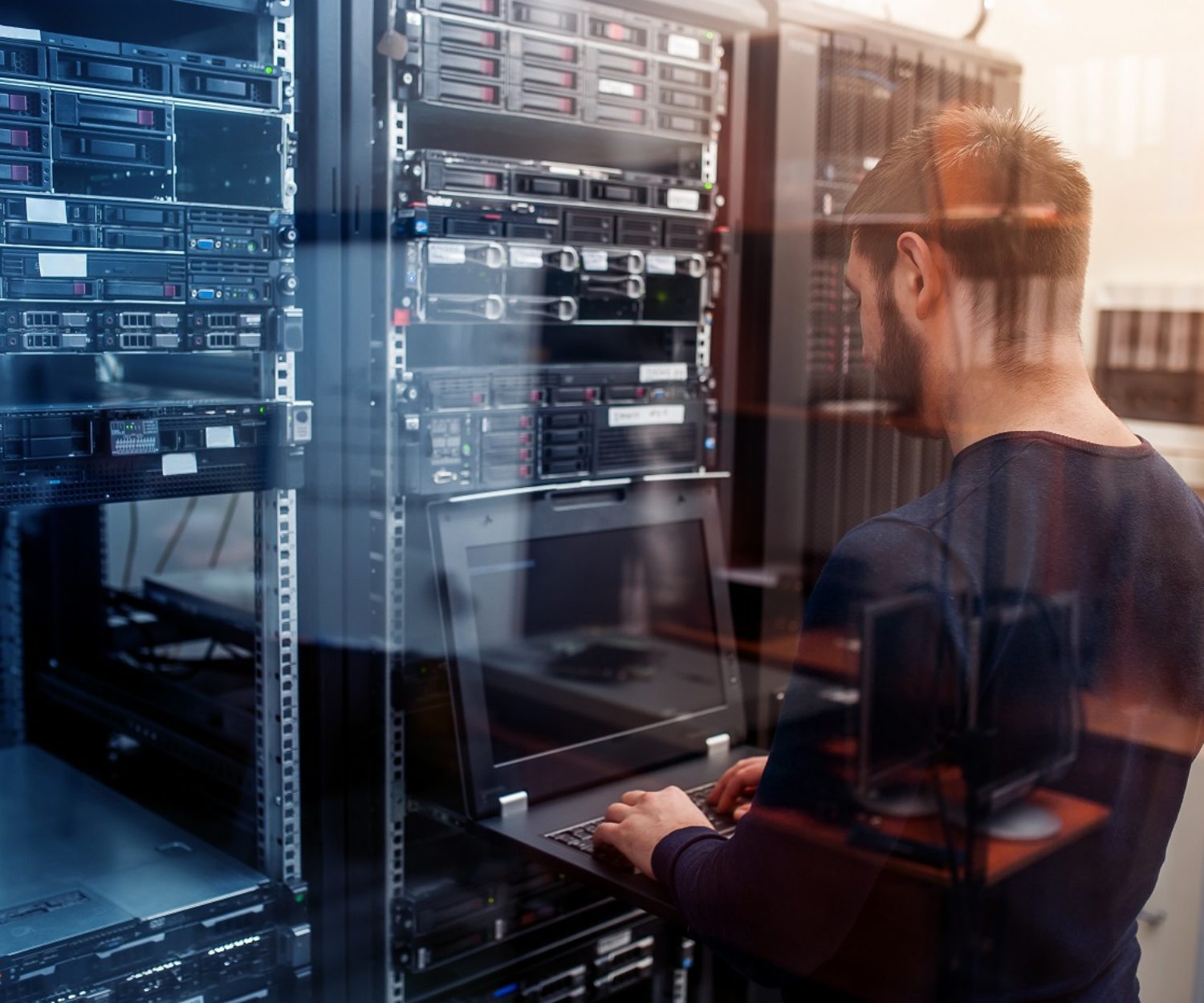 young it engeneer business man with thin modern aluminium laptop in network server room